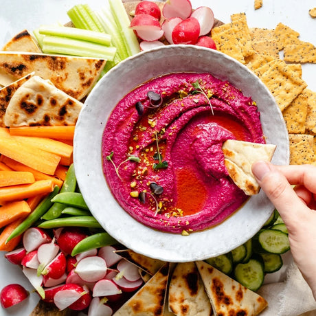 dipping cracker in hummus image